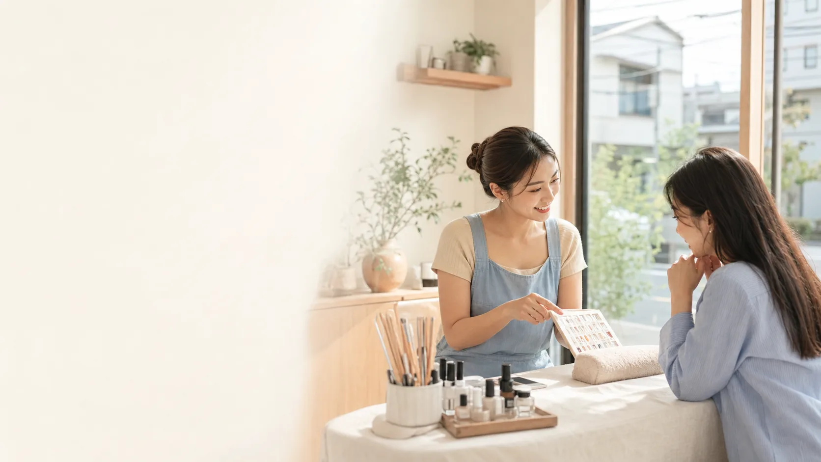 Nhân viên tiệm làm đẹp giới thiệu bảng mẫu màu cho khách tại một tiệm ở Nhật